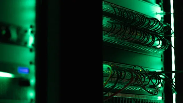 Server rack with cabling lit green in a dark room